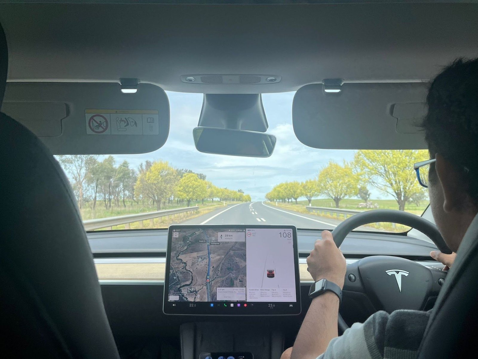 Mahmud behind the wheel of his 2023 Tesla Model Y on a road trip